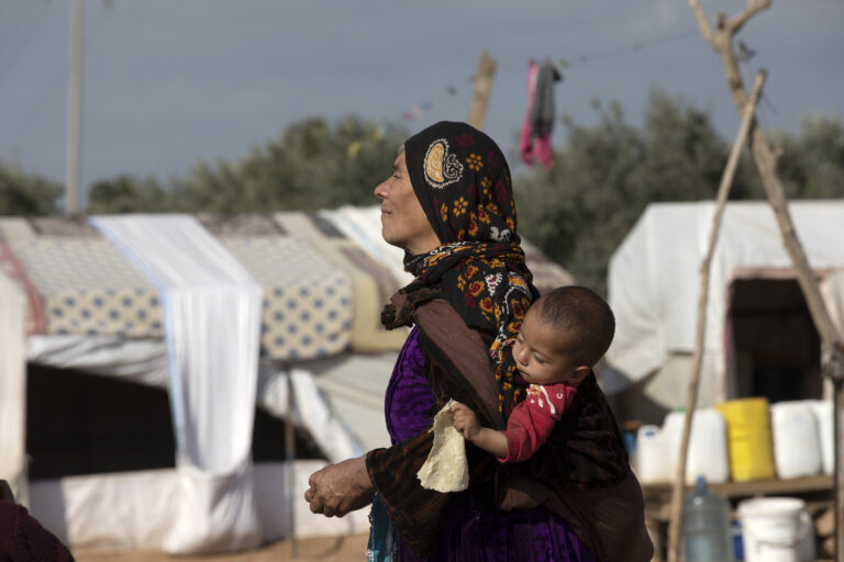 Mujer con un niño a la espalda. Siria