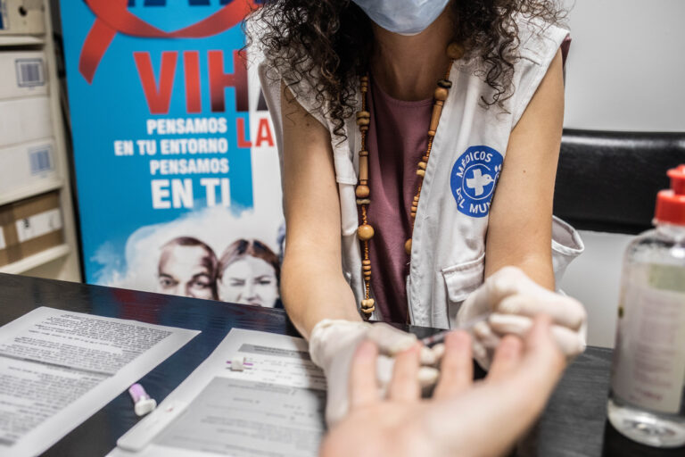 Una técnica de Médicos del Mundo Andalucía hace una prueba rápida de VIH en la sede de Sevilla. Fotografía de César Dezfuli.