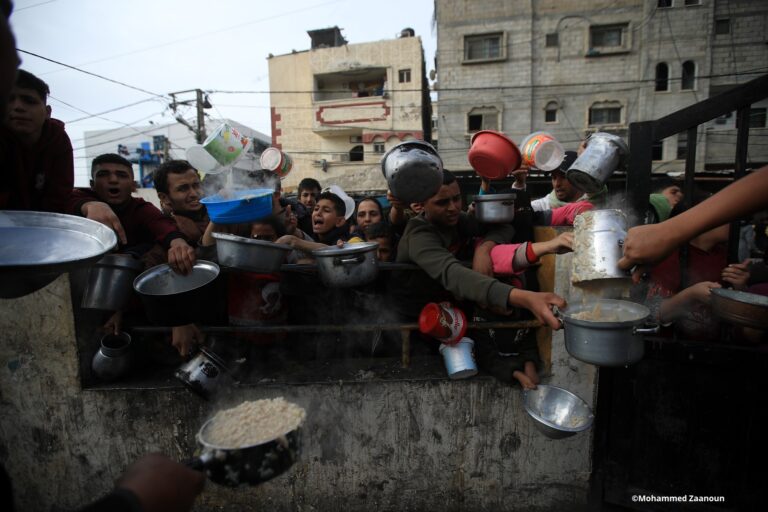 Familias palestinas esperan la distribución de alimentos a personas desplazadas